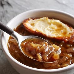 a bowl filled with stew and bread on top of a table