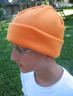 a young man wearing an orange hat and glasses