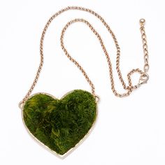 a heart shaped moss covered necklace on a chain