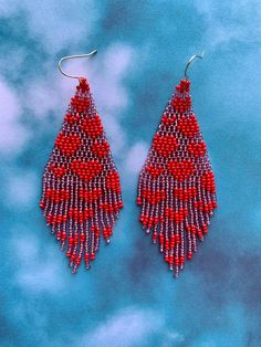 red and silver beaded earrings on blue background