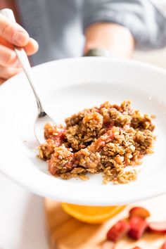 a person holding a white plate with food on it