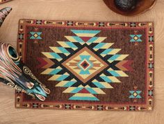 a brown rug with blue, red and yellow designs on it next to two vases