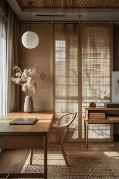 a wooden table sitting under a window next to a vase with flowers on top of it