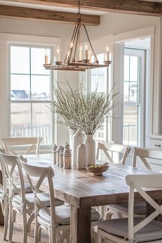 a dining room table with chairs and a vase filled with flowers on top of it