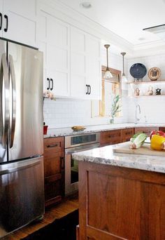 a kitchen with white cabinets and wood floors is featured in the article choose wood for your door