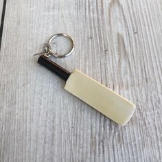 a knife shaped keychain sitting on top of a wooden table