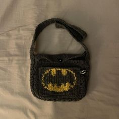 a batman purse is laying on a bed