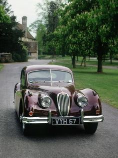 an old fashioned car is parked on the road