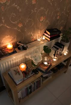 some books and candles are on a table