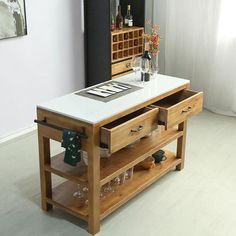 a kitchen island with wine glasses and bottles on it in front of a wall mounted cabinet