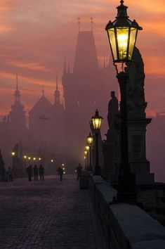 a street light sitting on the side of a road next to a tall clock tower