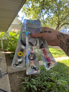 a person holding up several pairs of earbuds in their hand with tattoos on them