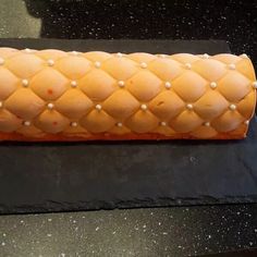 a cake shaped like a roll with pearls on it