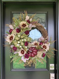 a green door with a wreath and flowers on it