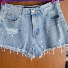 Hot Beautiful High-Waisted Light Denim Shorts Covered With Different Shape Icy Dazzling Rhinestones On The Front With Dangling Rhinestones Just Above The Hem Of Each Leg. Distressing On Both Back Pockets And Some On The Front Give These Feminine Shorts Just Enough Edge To Make Them Perfect! Great For Summer Parties Or Festivals. Minimal Stretch. Measurements: Waist - 15 In Length- 13in Inseam - 3 1/4in Materials: 73% Cotton 13% Polyester 13% Viscose 1% Other Fibers Denim Bottoms With Rhinestones, Short Length, Denim Bottoms With Rhinestones Short Length, Denim Rhinestone-embellished Short Bottoms, High Rise Denim Bottoms With Rhinestones, Summer Denim Bottoms With Rhinestones, Casual Medium Wash Rhinestones Bottoms, Embellished Casual Jean Shorts, Rhinestone Denim Jean Shorts, Summer Blue Bottoms With Rhinestones