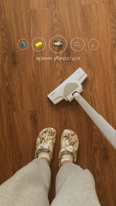 a person standing on the floor next to a mop with buttons and icons above it