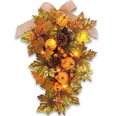 an arrangement of autumn leaves and acorns with lights