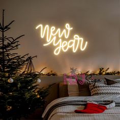 a neon sign that says new year on the wall above a bed with christmas decorations