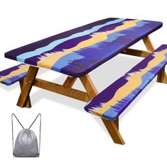 a purple and yellow picnic table sitting next to a bag