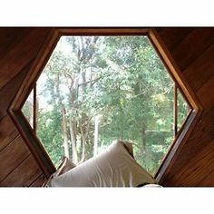 a window in the side of a wooden building with a blanket on it's back