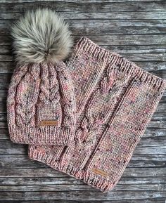 a pink knitted hat with a pom - pom on top of it