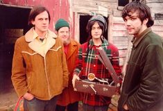 a group of young men standing next to each other in front of a red building