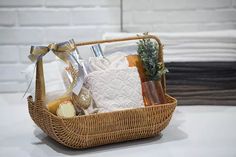 a wicker basket filled with towels and soaps on top of a white table