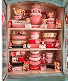 a cabinet filled with lots of pink and white dishes