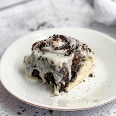 a white plate topped with a piece of cake covered in frosting