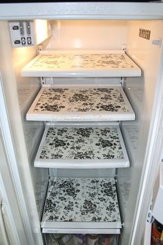 an open refrigerator with four different designs on the door and bottom shelves, all in black and white