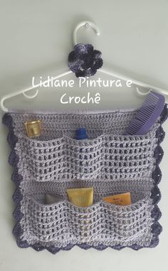 a crochet purse hanging on a hook with the name lidane pintura e crochet