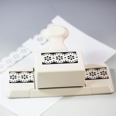 a white rubber stamper sitting on top of a piece of paper next to a tape dispenser