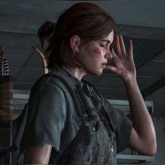 the last of us's character is holding her hand up to her face while standing in