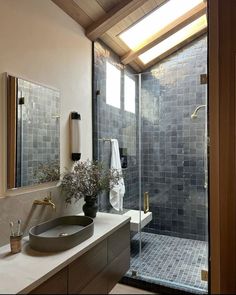 a bathroom with a sink, mirror and shower stall