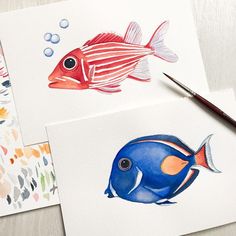 three watercolor paintings of fish on white paper with paintbrushes next to them