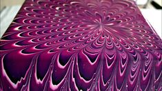 an intricate design is shown on the surface of a piece of art that appears to be purple