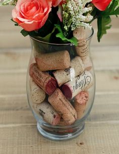 a glass vase filled with wine corks and flowers