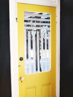 a bright yellow door with black walls and white trim