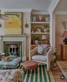 a living room filled with furniture and a fire place under a painting on the wall