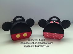 two mickey mouse purses sitting on top of a white table next to each other