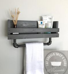 a bathroom shelf with some toiletries on it and a white towel hanging from the wall