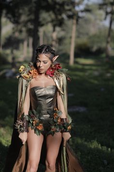 a woman dressed as a fairy standing in the grass