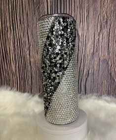 the vase is decorated with black and silver sequins on it's base