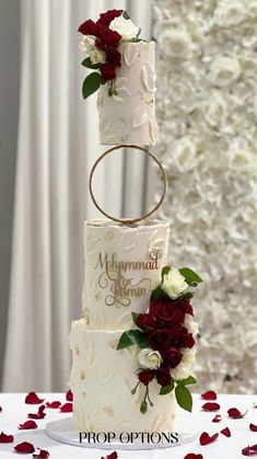 a three tiered wedding cake with red and white flowers