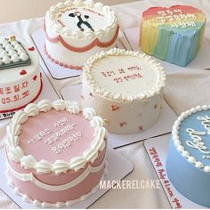 there are many cakes on the table with different frosting colors and designs for each cake