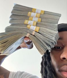 a woman holding stacks of money in front of her face