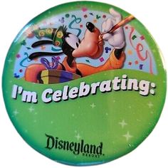 a green button with the words i'm celebrating mickey mouse and pluto on it