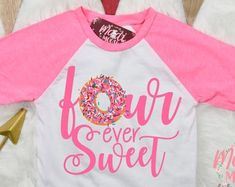 a pink and white shirt with donuts on it that says flour, never sweet