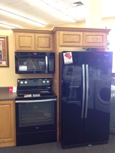 a kitchen with black appliances and wooden cabinets