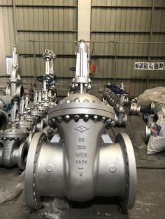 a large metal ball valve sitting inside of a factory floor next to other valves and pipes